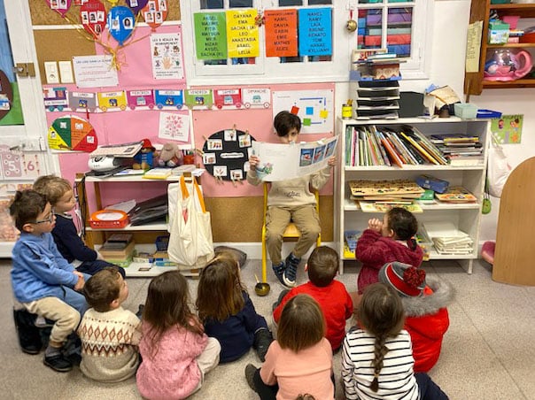 un élève de cm1 fait la lecture à la classe de maternelle moyenne section